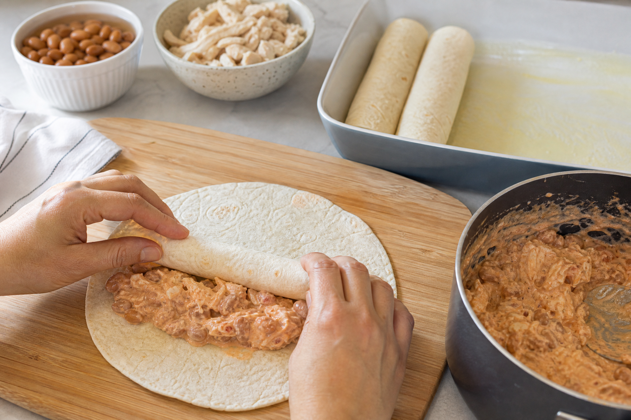 Cream cheese melted into salsa makes a cheap filling taste rich. Roll, line up, cover, bake